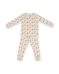A two-piece long-sleeve pajama set featuring a light beige and cream base with a repeating pattern of brown hot air balloons and small white clouds, laid flat on a white background.