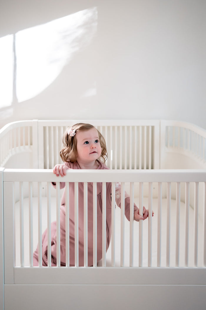 Baby flicka i rosa sovpåse