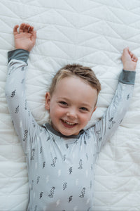 Glad pojke i pyjamas med blixtar