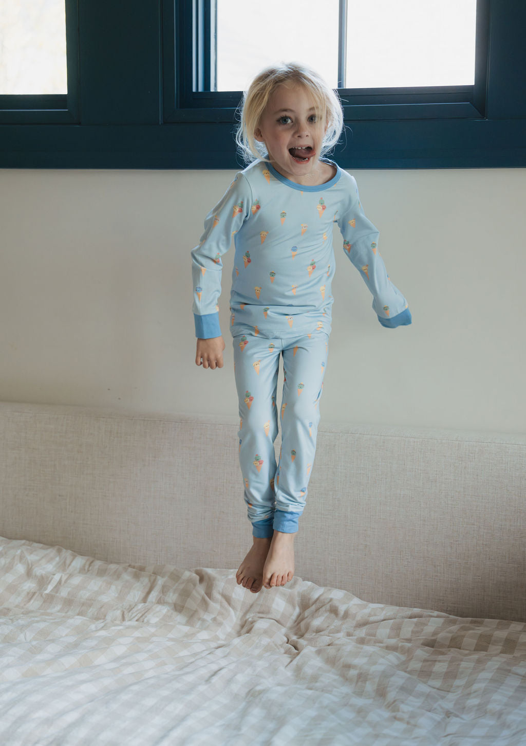 Barn hoppar i sängen i pyjamas