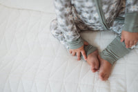 Närbild på babypyjamas i grön med blommor