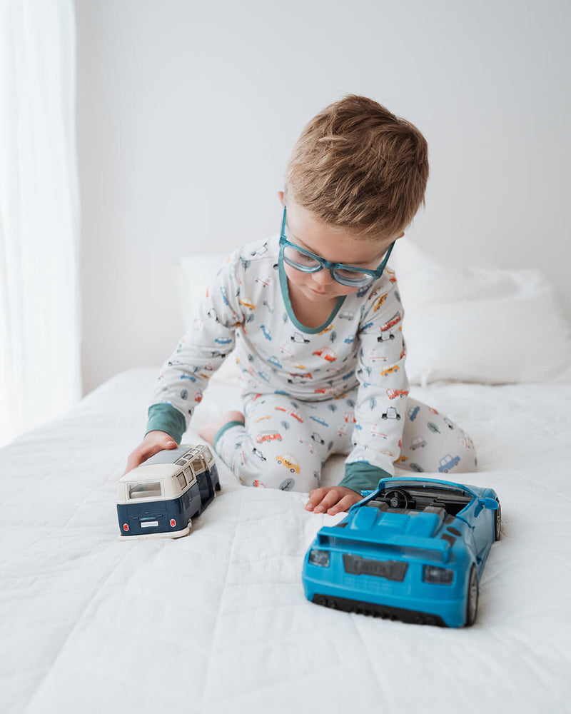 Child playing with toy suitcases on a bed