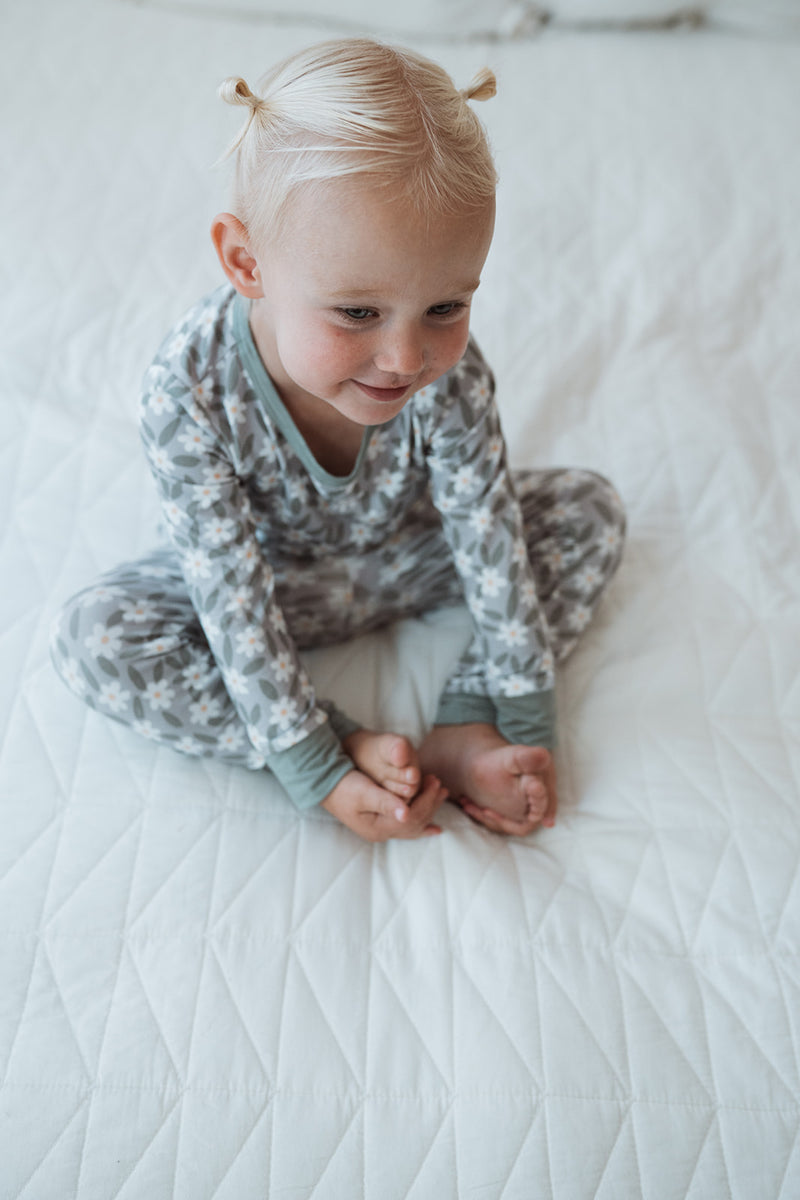 Barn som myser i sängen i pyjamas
