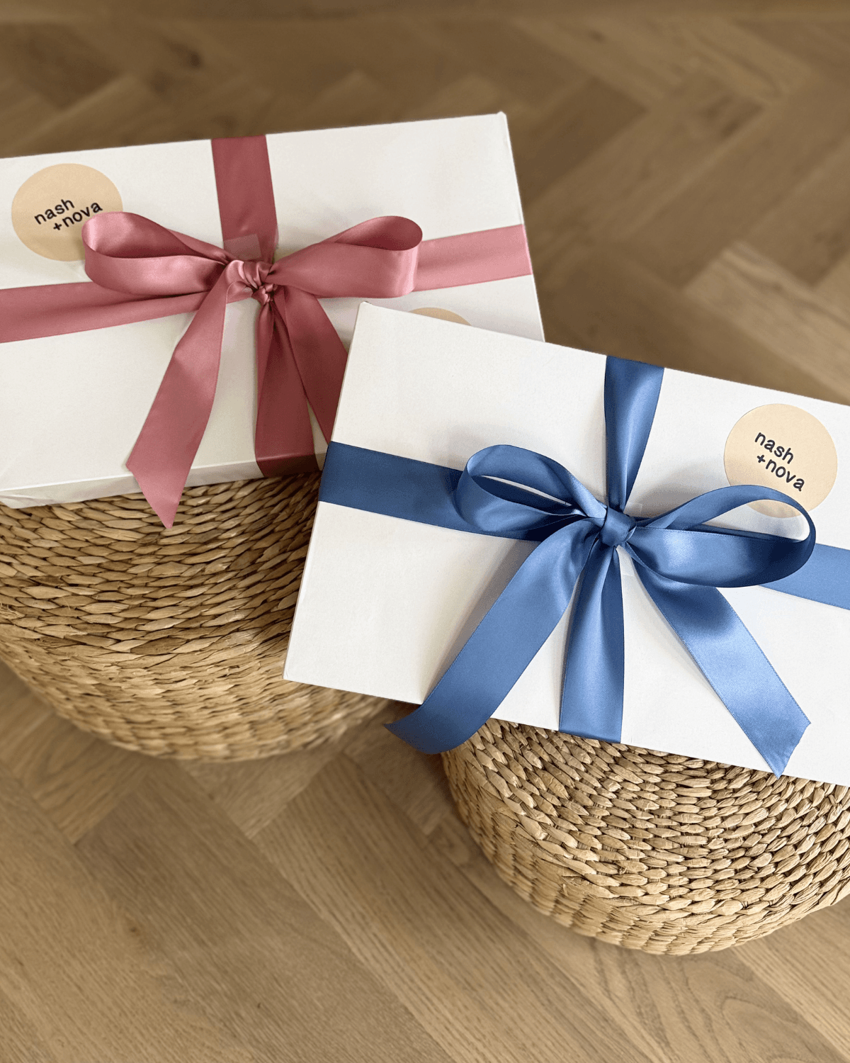 Two gift boxes with ribbons on a woven stool